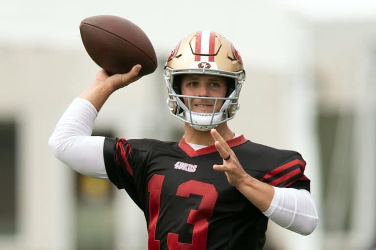 Brock Purdy goes to throw a football.