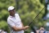 Scottie Scheffler holds a club.