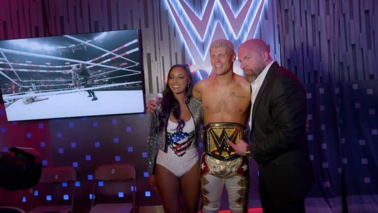 Cody Rhodes stands with Triple H and Brandi.