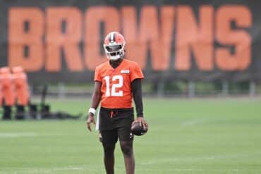 Shedeur Sanders holds a football.