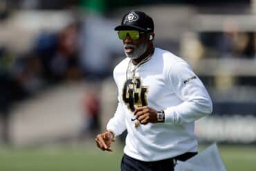 Deion Sanders runs onto the field.