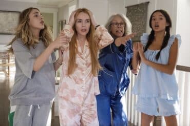 Four women look and point.