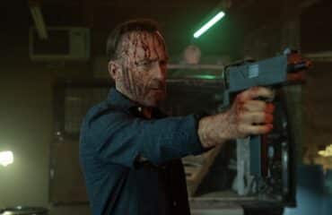 A man holds a gun up.