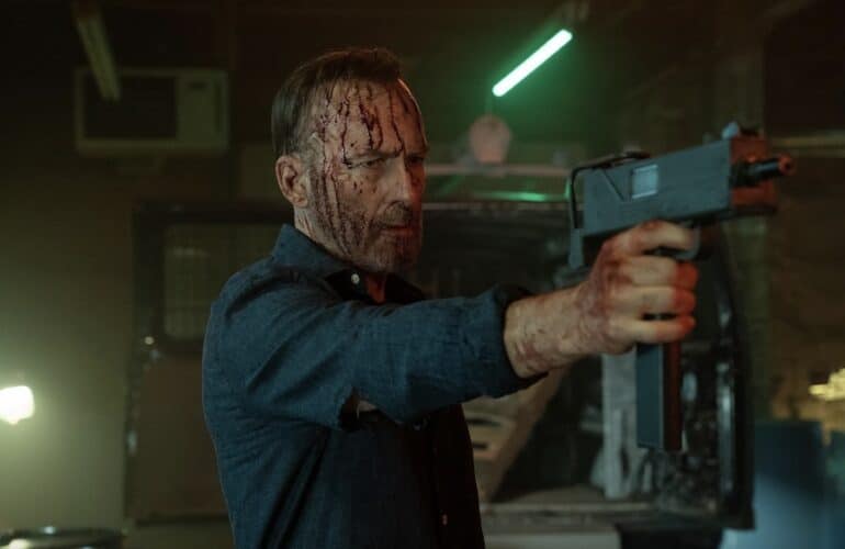 A man holds a gun up.