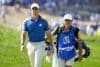 Rory McIlroy walks on the field.
