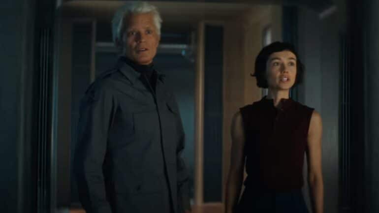 A man stands next to a woman.