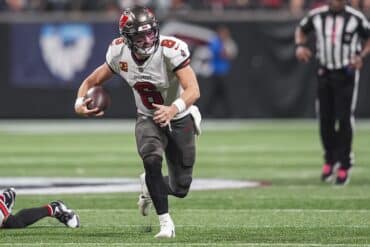 Baker Mayfield holds the ball and runs.