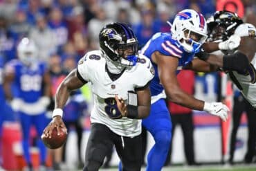 Lamar Jackson holds the ball and runs.