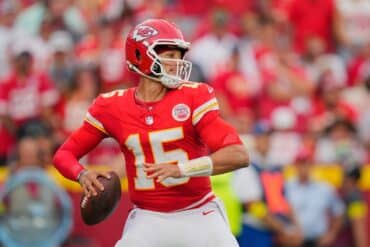 Patrick Mahomes holds the ball and goes to pass.
