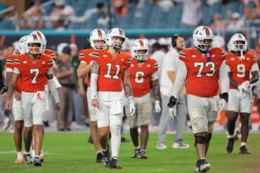 The Miami Hurricanes walk on the field.