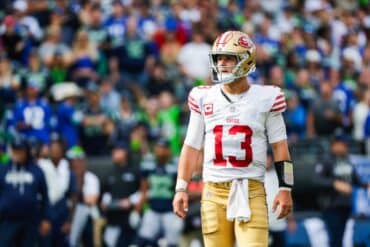 San Francisco 49ers quarterback Brock Purdy stands on the field.