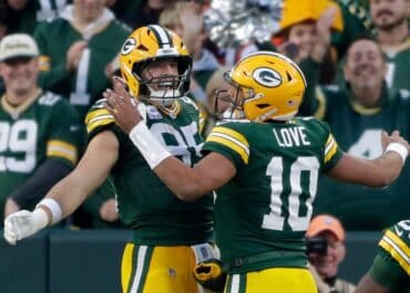 Two Packers players chest bump.