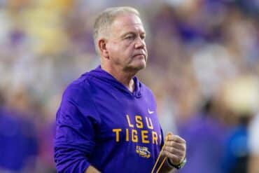Brian Kelly hold something in his hand.