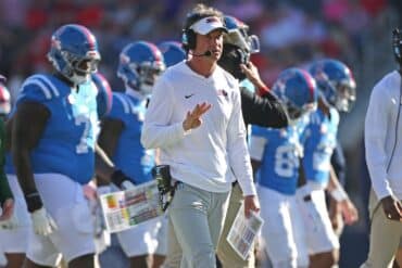 Mississippi Rebels head coach Lane Kiffin puts his hand up.