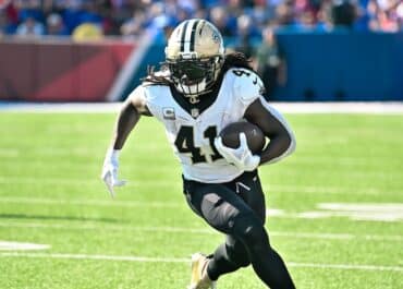 Alvin Kamara prepares to run the ball.