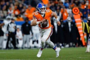 Bo Nix holds a ball and walks.