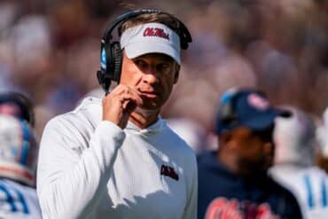 Ole Miss head coach Lane Kiffin talks into mic.