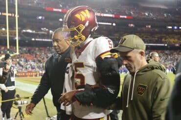 Washington Commanders quarterback Jayden Daniels walks off the field.