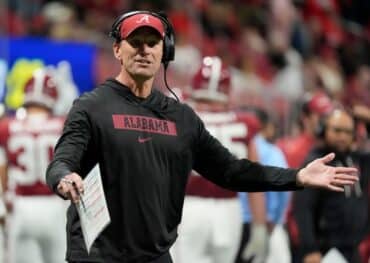 Alabama head coach Kalen DeBoer puts his arms out.