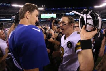 Eli Manning touches Drew Brees' shoulder.