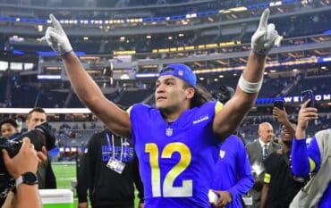 Puka Nacua puts his arms in the air.