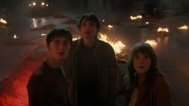 Two kids and a woman stare in Stranger Things.