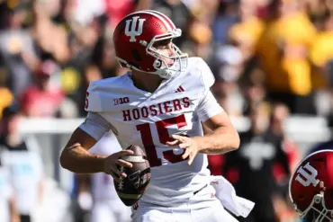 Quarterback wearing Indiana Hoosiers uniform throws a football during a game.