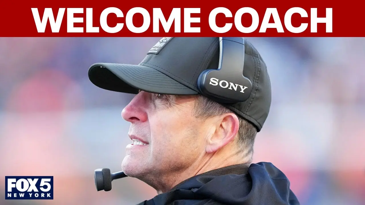 Side profile of a coach wearing a black cap and headset, with a focused expression.