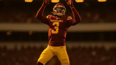 NFL wide receiver in Washington Commanders uniform making athletic catch in stadium with dramatic lighting