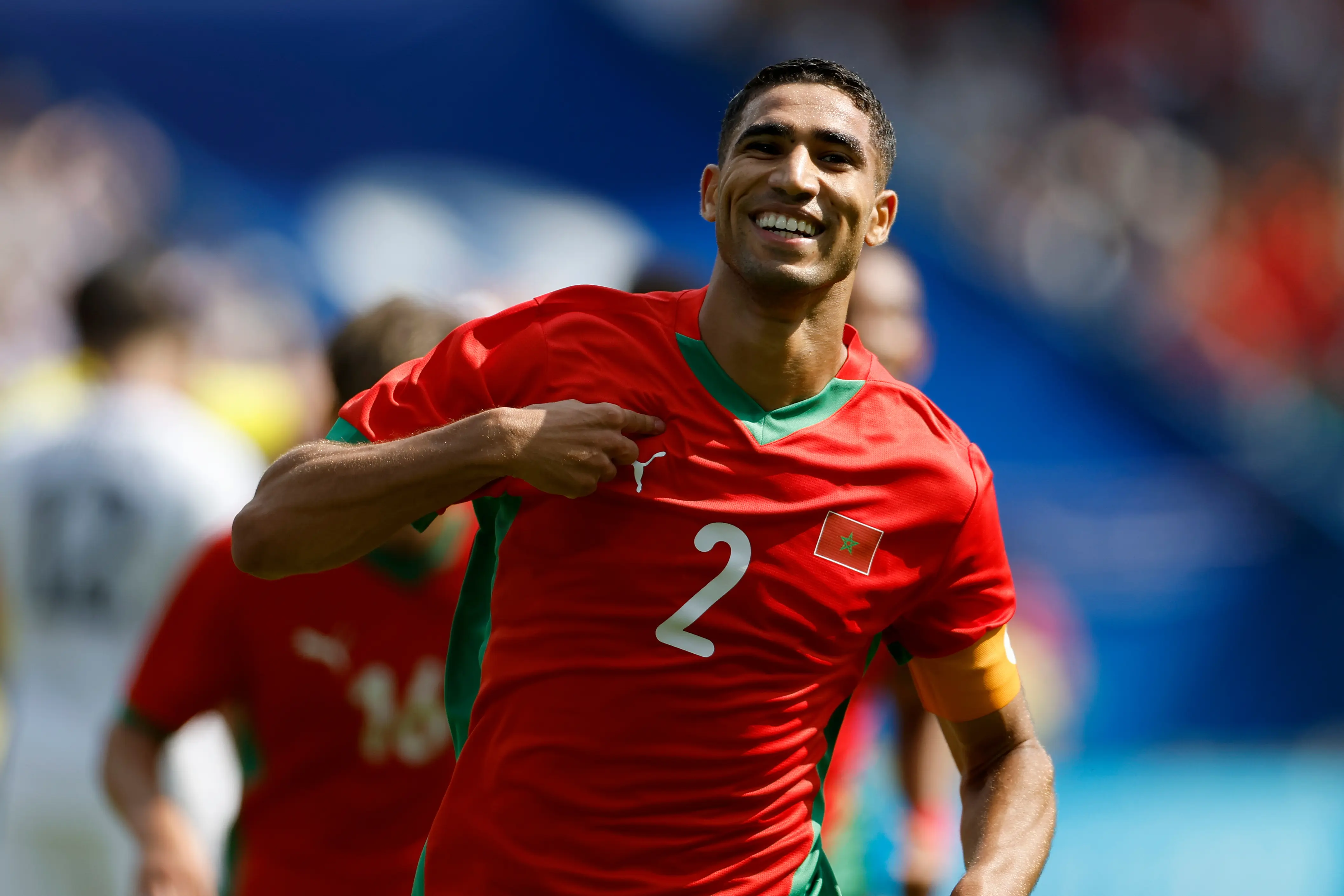 Achraf Hakimi celebrating in Morocco national team jersey during a match.
