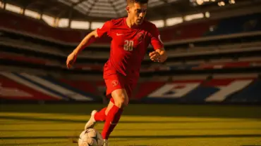 Turkish soccer player attacking with ball at modern stadium during World Cup 2026 match