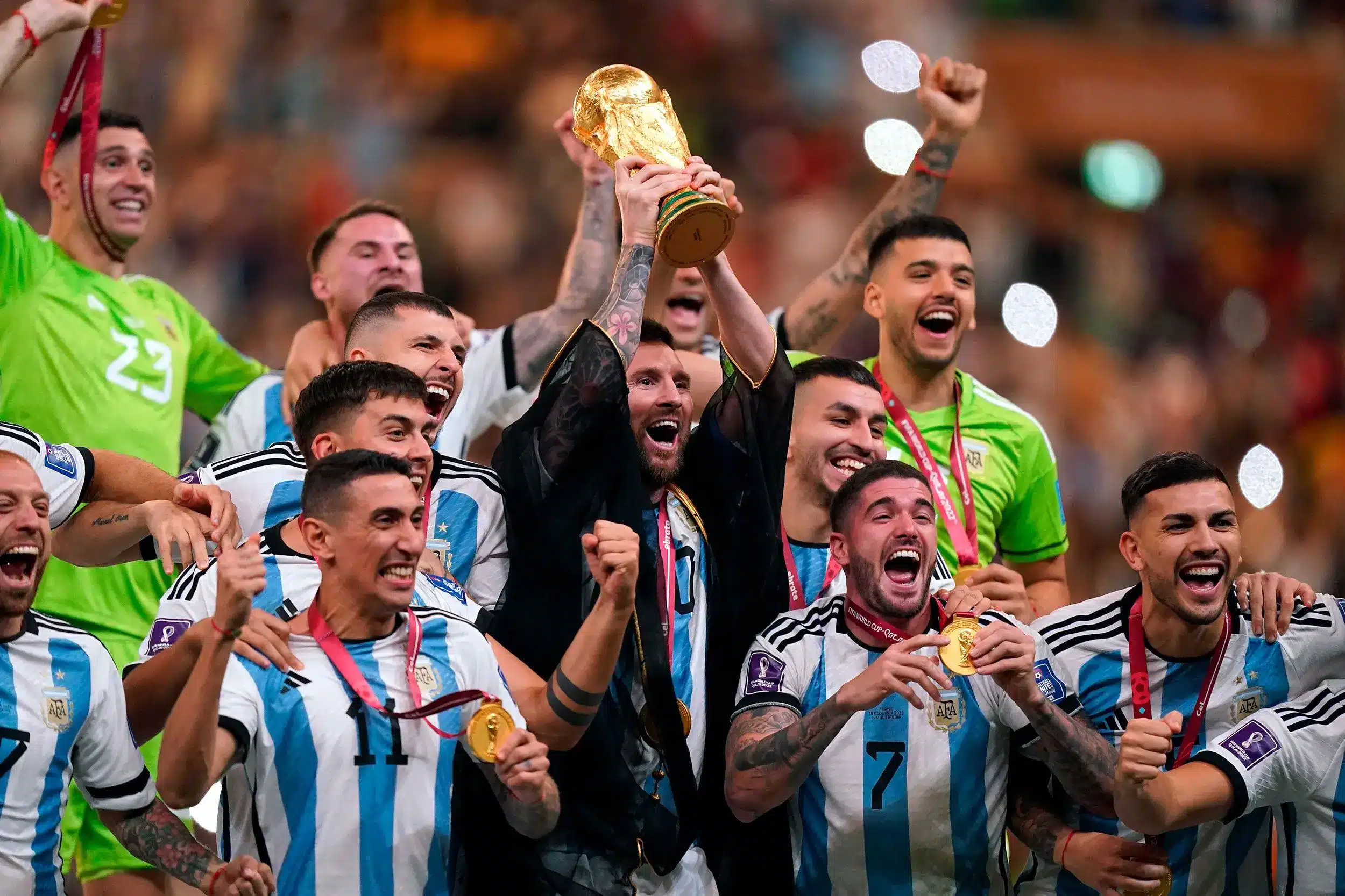 Argentina football team celebrates winning the World Cup, with Messi lifting the trophy.