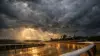 Saratoga Race Course dirt track under dramatic storm clouds with wet surface and moody lighting