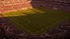 Aerial view of World Cup soccer stadium with pristine pitch and crowd during golden hour