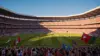 Packed World Cup soccer stadium with players on field and excited fans during an international match