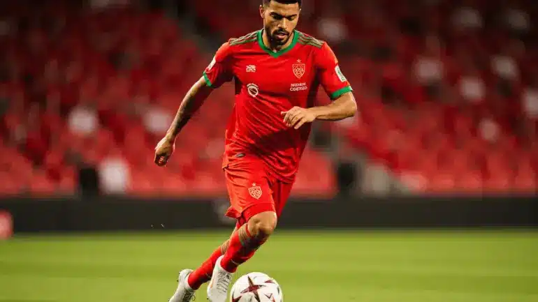 Morocco soccer player dribbling in red jersey during international match action shot
