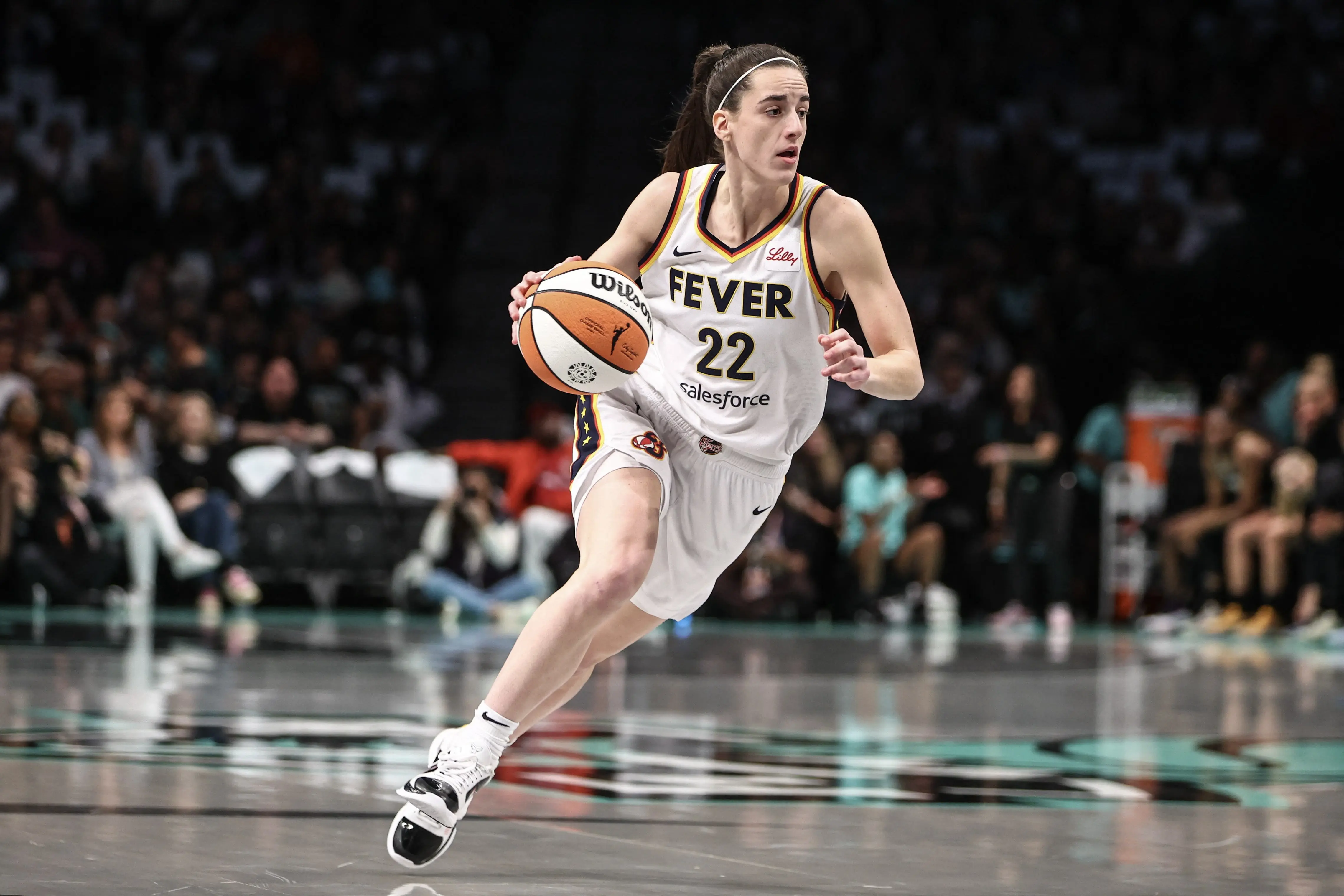 Caitlin Clark of the Indiana Fever dribbling a basketball during a game.