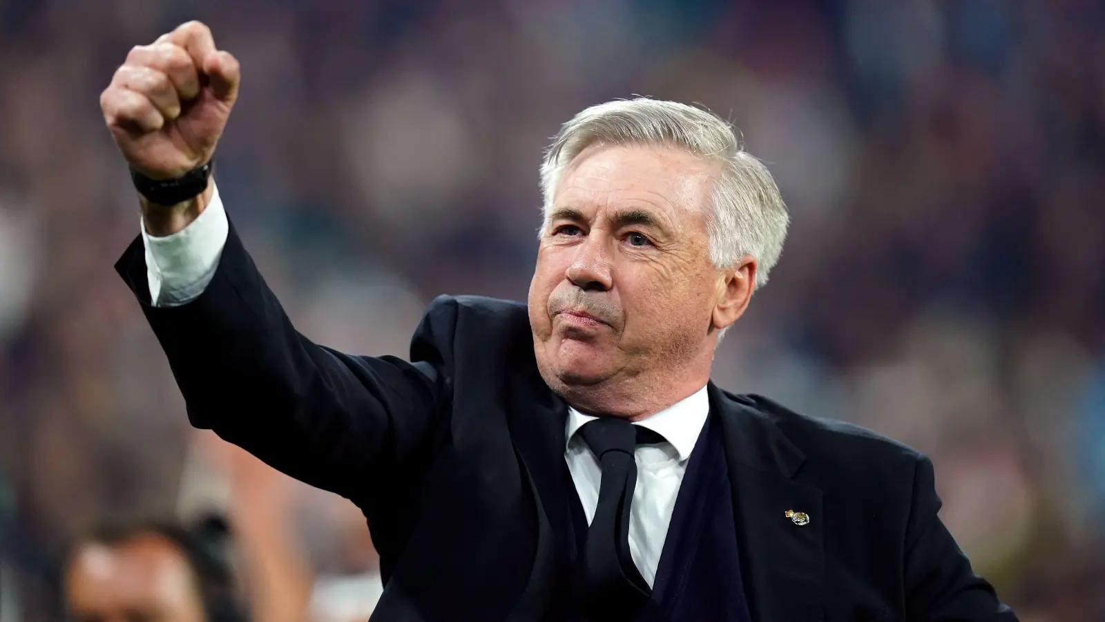 Carlo Ancelotti raising his fist in celebration during a match.