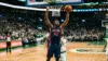 NBA center defending the rim during intense basketball game action with raised arms