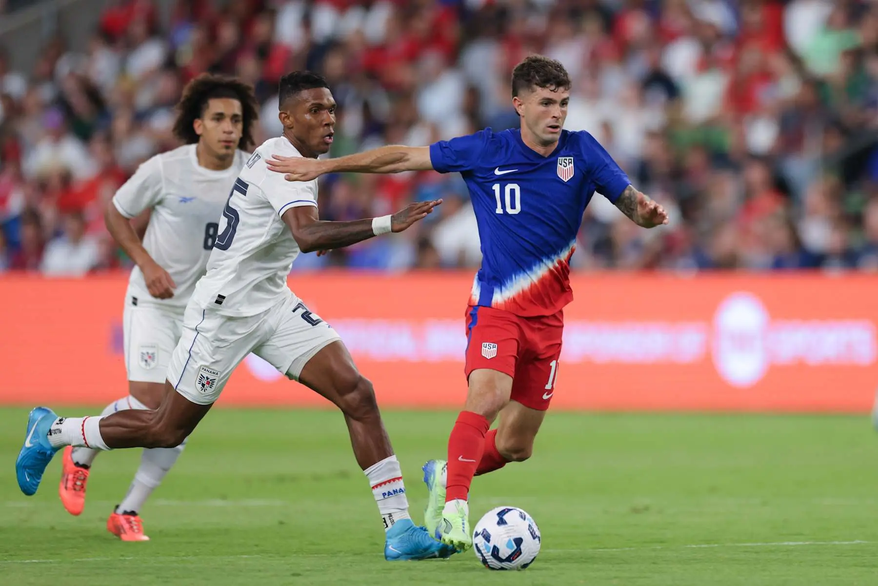 Christian Pulisic dribbling during a USMNT match against Panama.