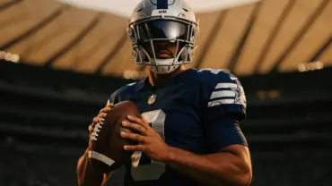 Cowboys quarterback in uniform on sideline ready for action at AT&T Stadium