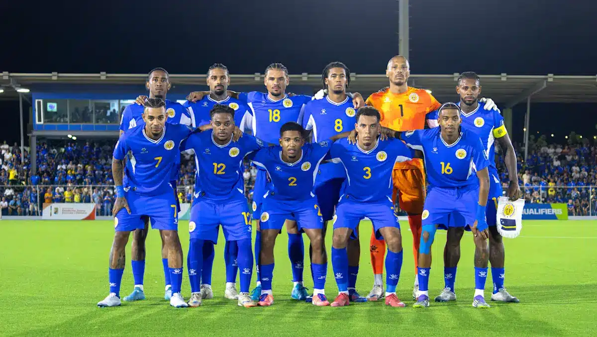 Curacao national football team posing for a team photo in blue jerseys.