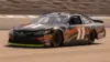 NASCAR Cup Series race car speeding through turn at Pocono Raceway in dramatic action shot