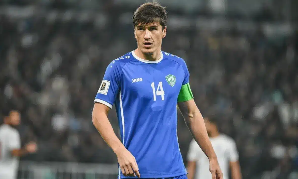 Eldor Shomurodov of Uzbekistan national team in blue jersey on the field.