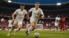 England players in white kit attacking during World Cup match at packed stadium with dramatic lighting
