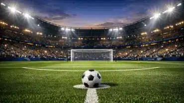 Football stadium at dusk with ball on penalty spot during 2026 World Cup match