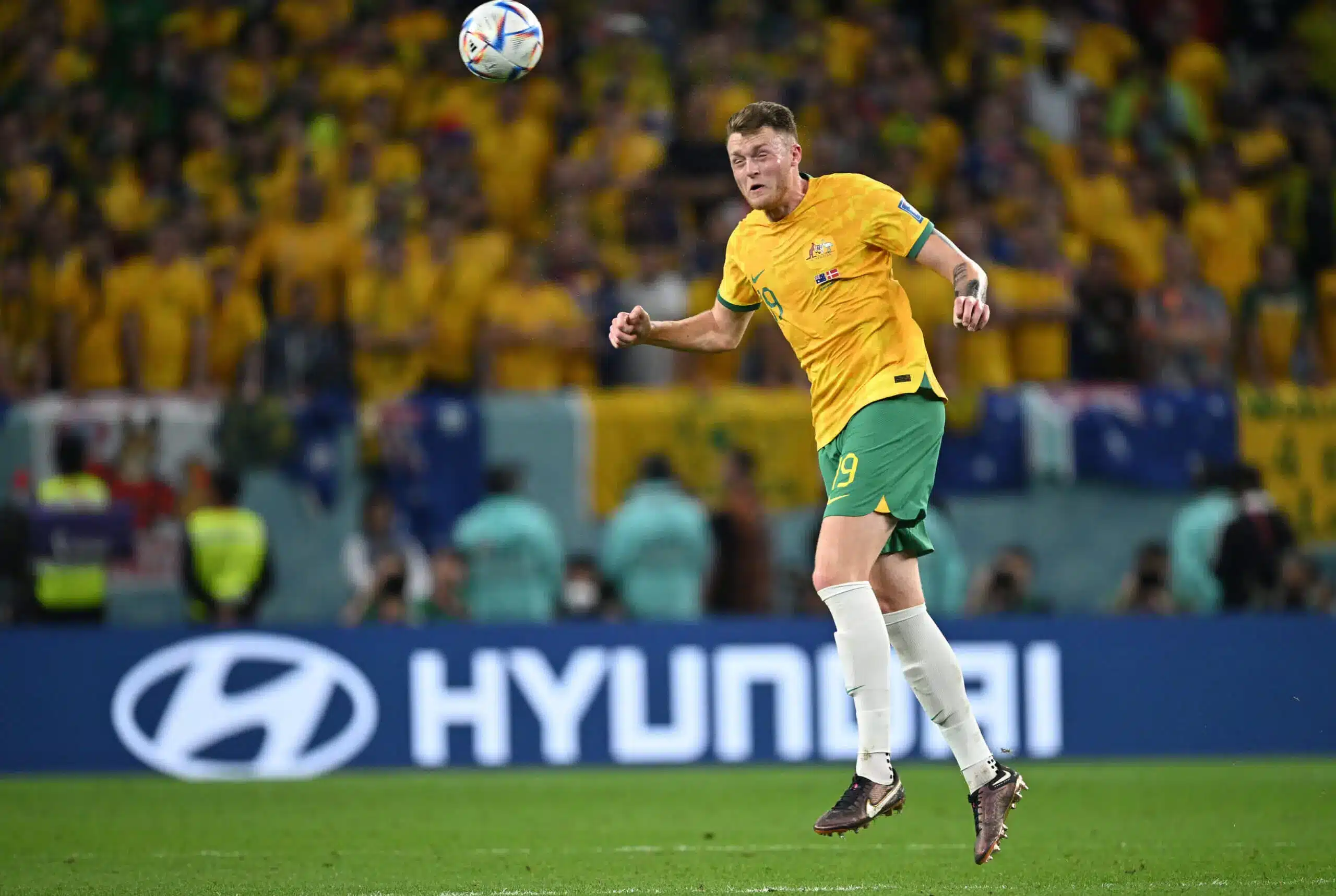 Harry Souttar of Australia jumps to head the soccer ball during a match.