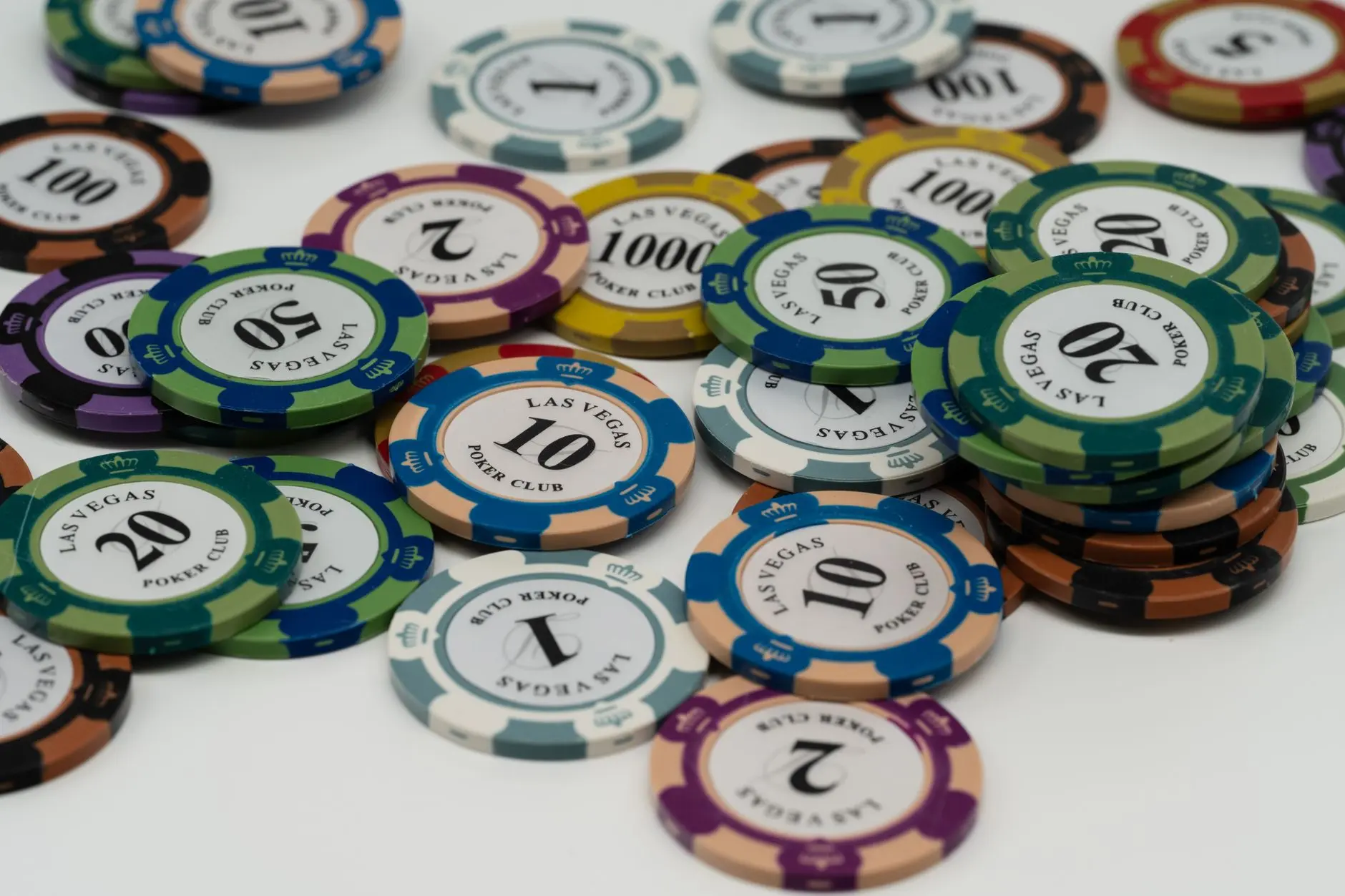 A diverse pile of colorful casino poker chips from Las Vegas Poker Club.