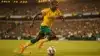 Australian soccer player Nestory Irankunda dribbling during World Cup match in yellow Socceroos kit