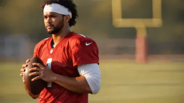 NFL quarterback in Cardinals uniform on practice field during contract negotiation minicamp